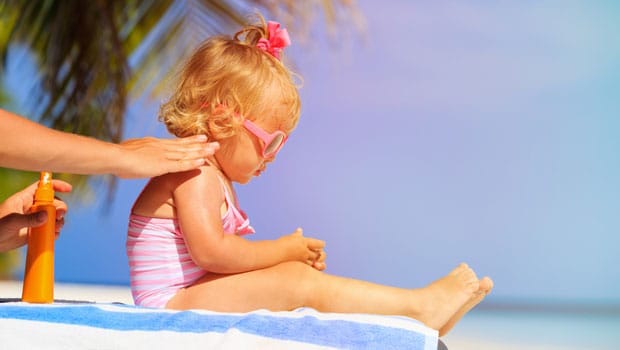 Image courtesy of Shutterstock Au pair applying sunscreen to child