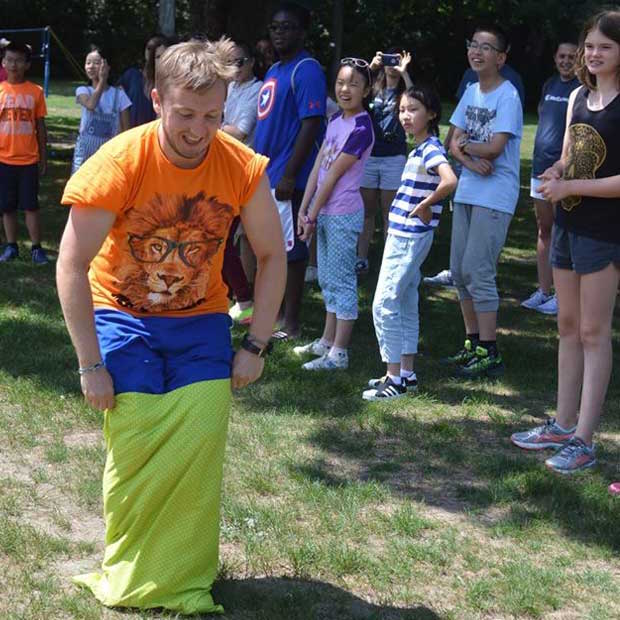 Image courtesy of Camp Stonewall Dennis from the Netherlands demonstrates The Kings Day sack race.
